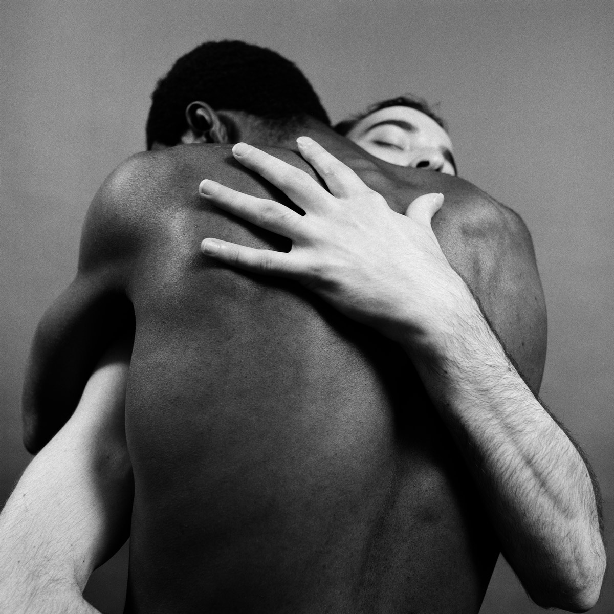 Black and white photograph of two men embracing one another