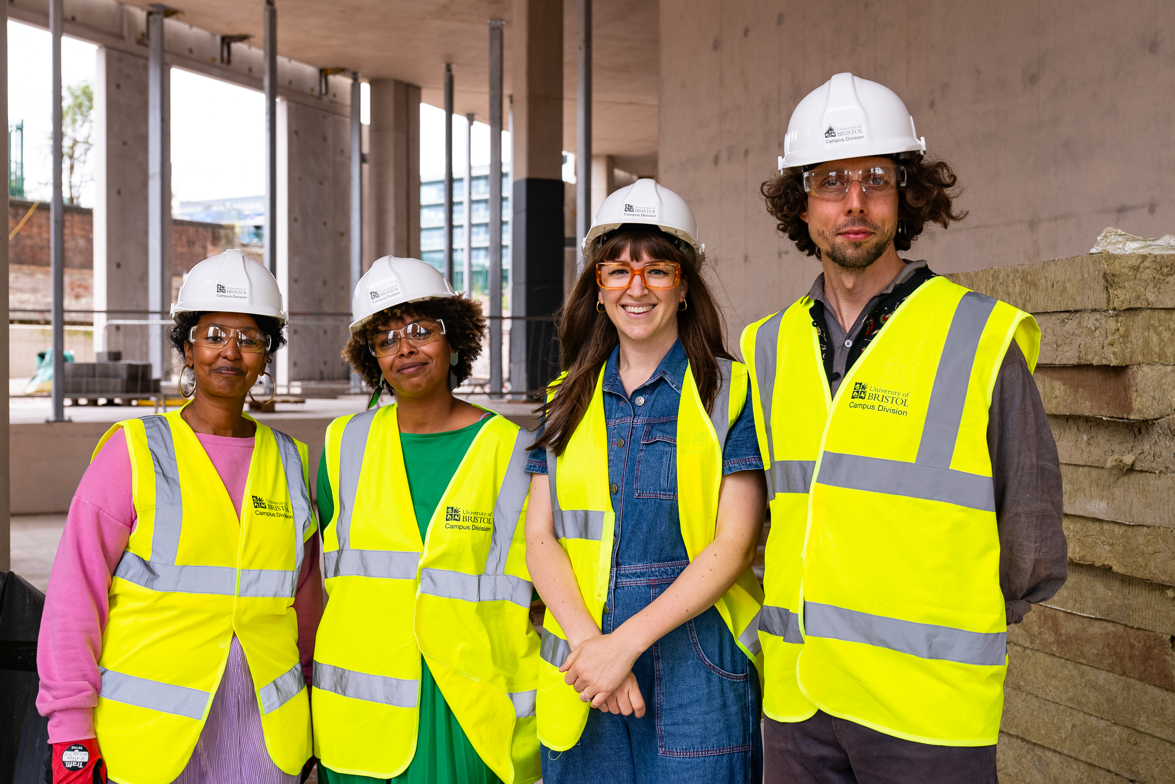 An group portrait of four artists involved in the Charting Change programme. All are wearing white helmets, yellow high vis vests.  